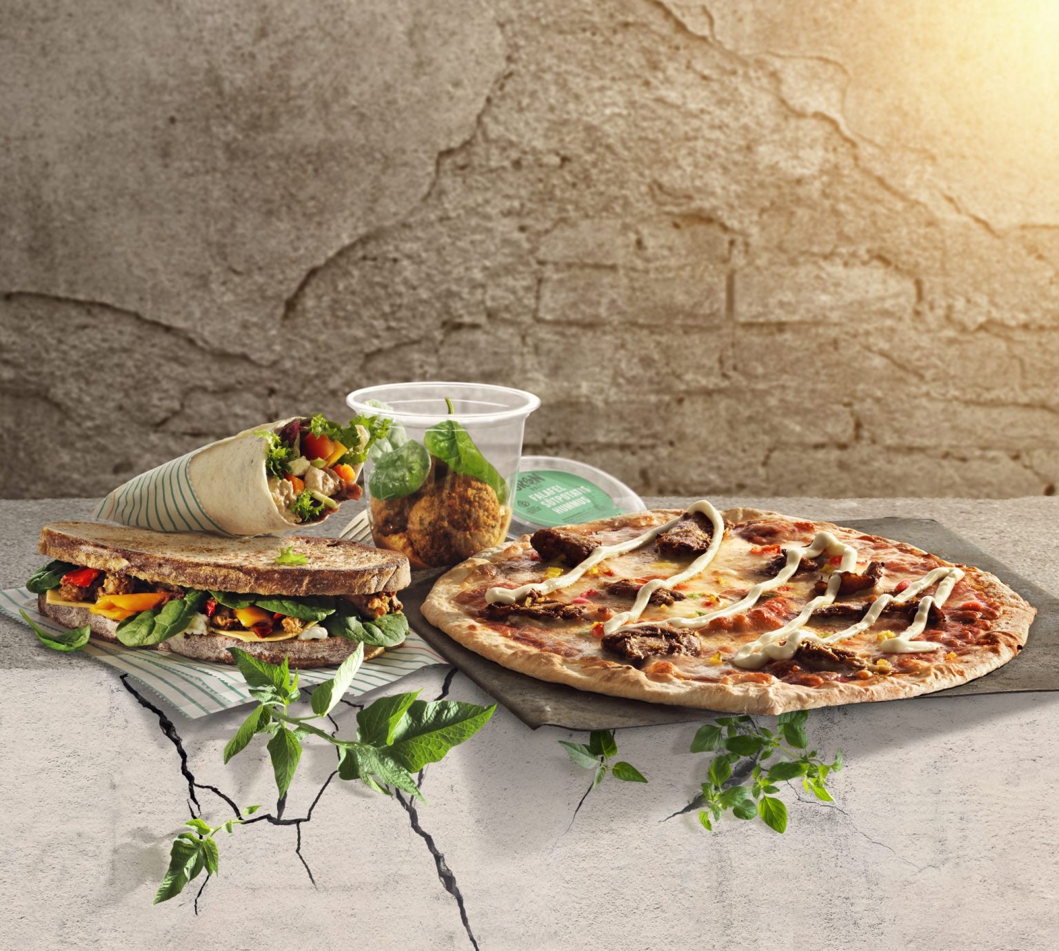 a sandwich and a pizza on a stone surface