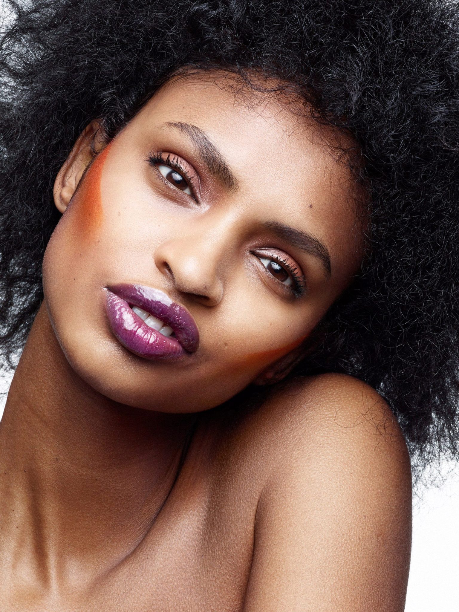 a woman with curly hair and purple lipstick