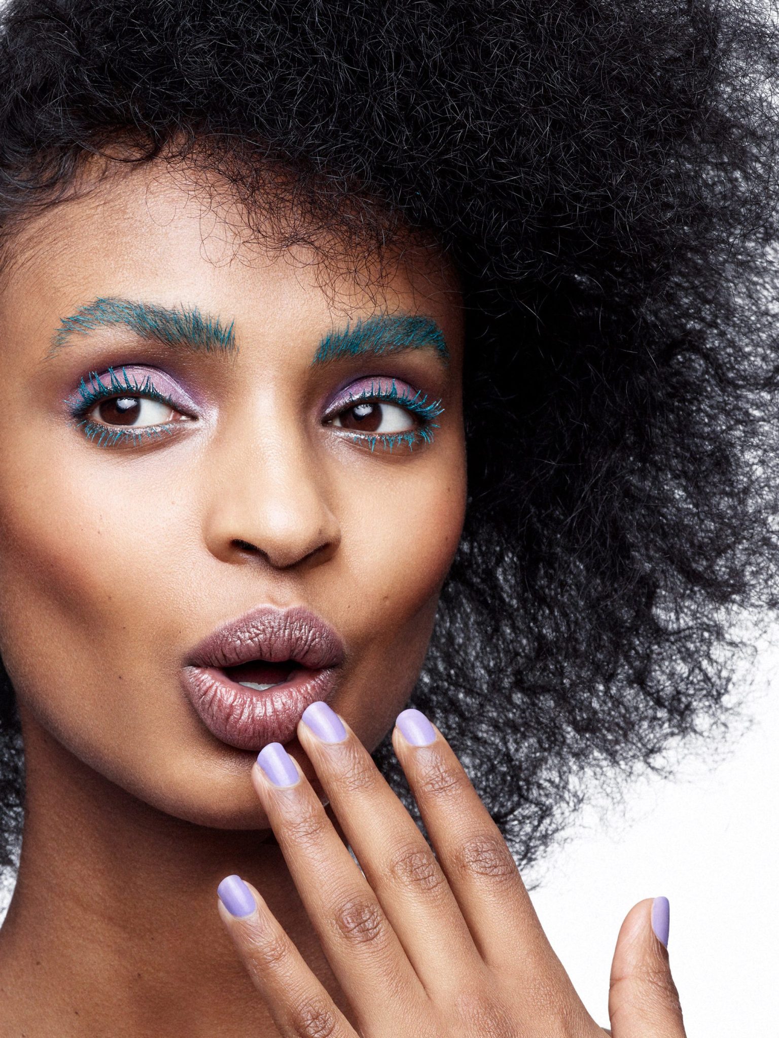 a woman with curly hair and blue makeup