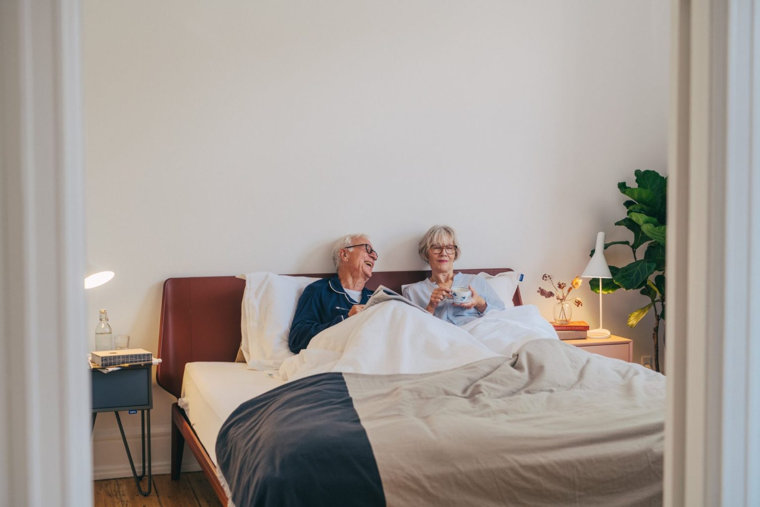 a man and woman sitting in bed