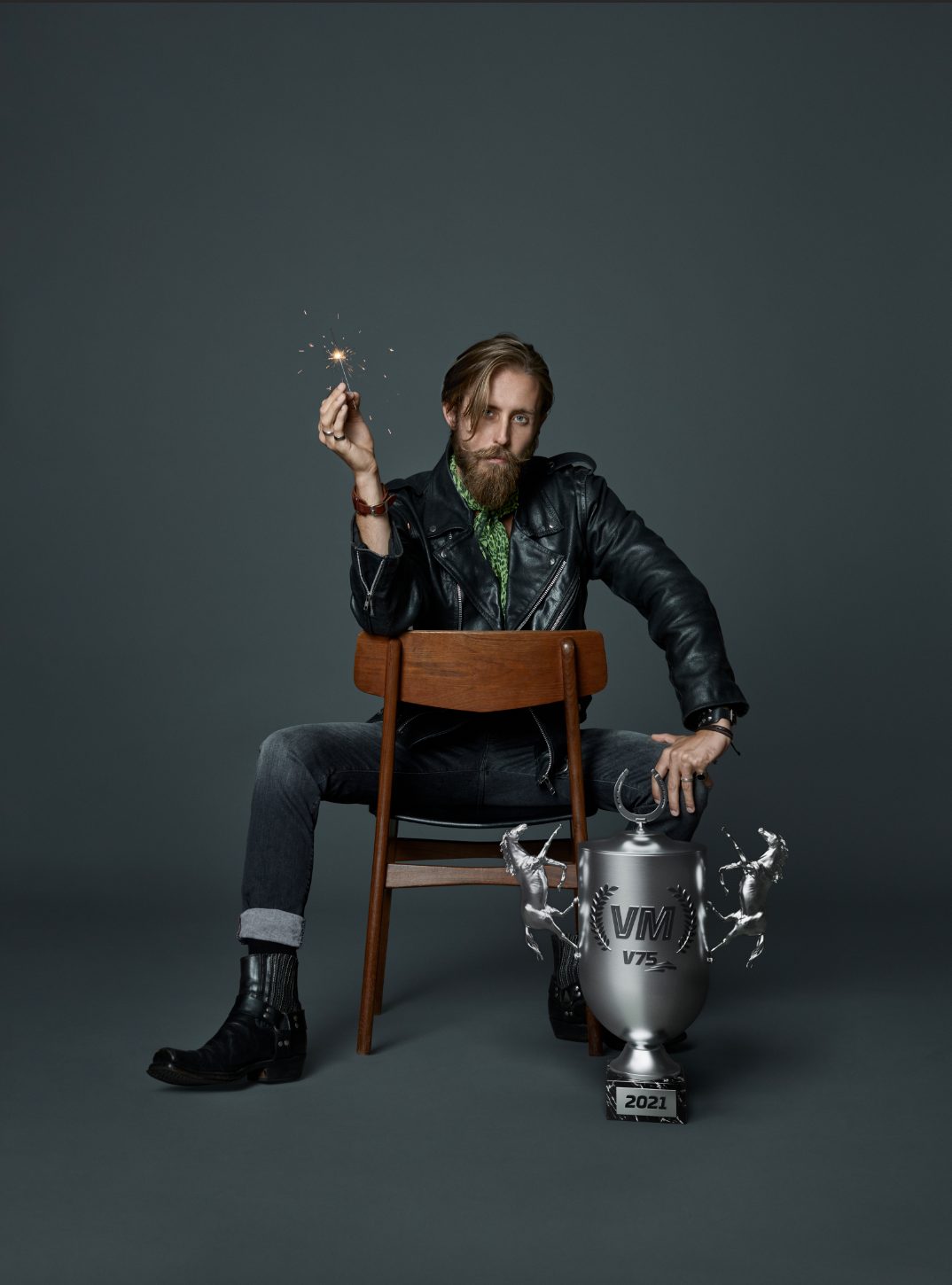 a man sitting in a chair holding a sparkler