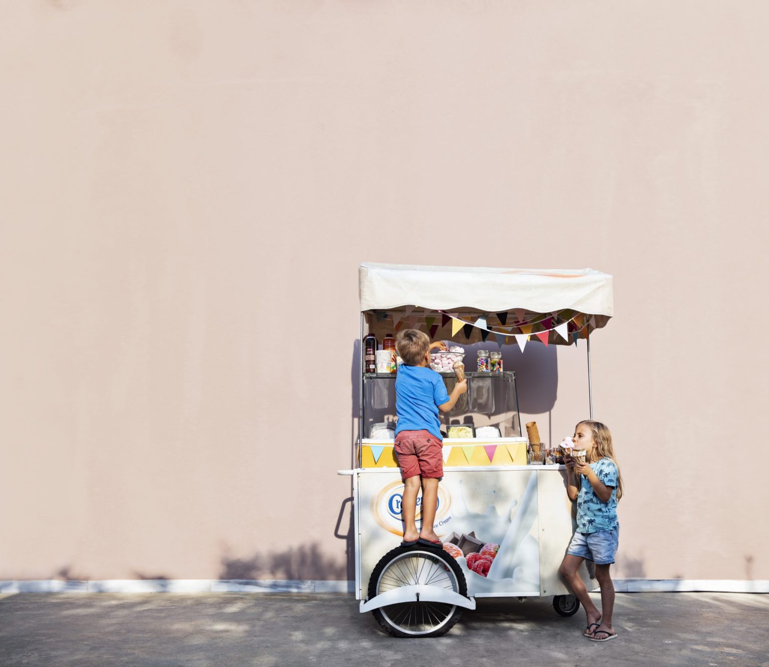 a two children standing on a cart