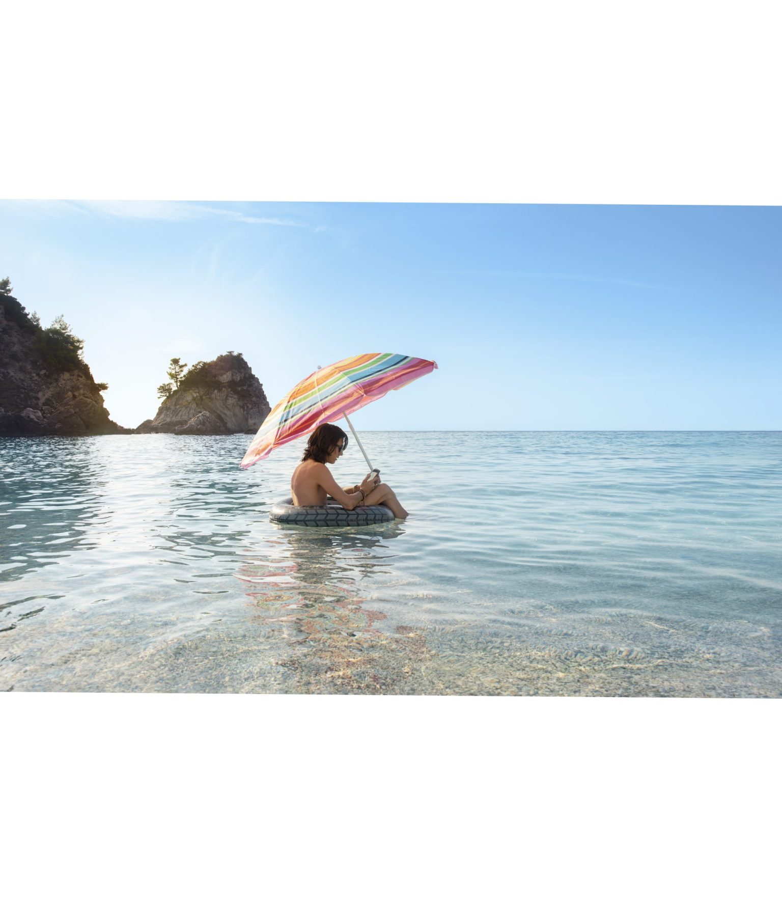 a person sitting in a tube with an umbrella in the water