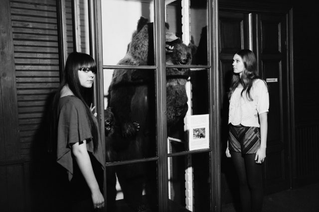 a group of women looking at a bear in a glass case