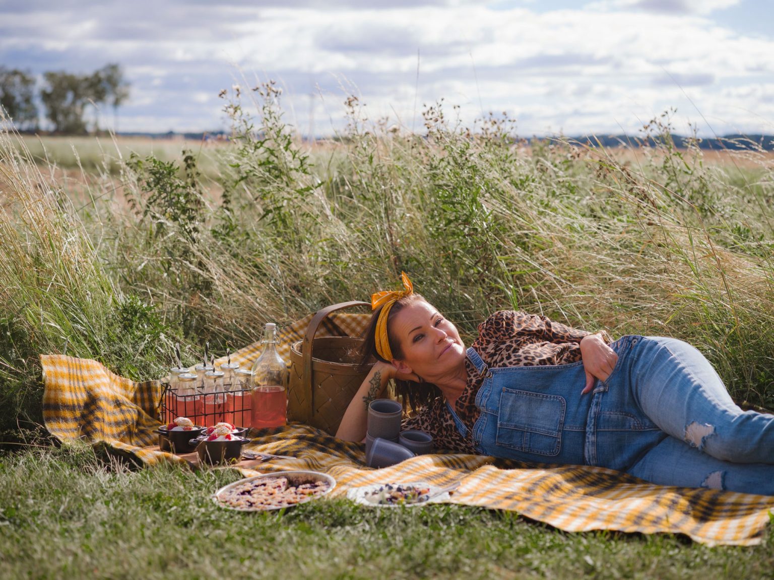 a woman lying on a blanket in a field