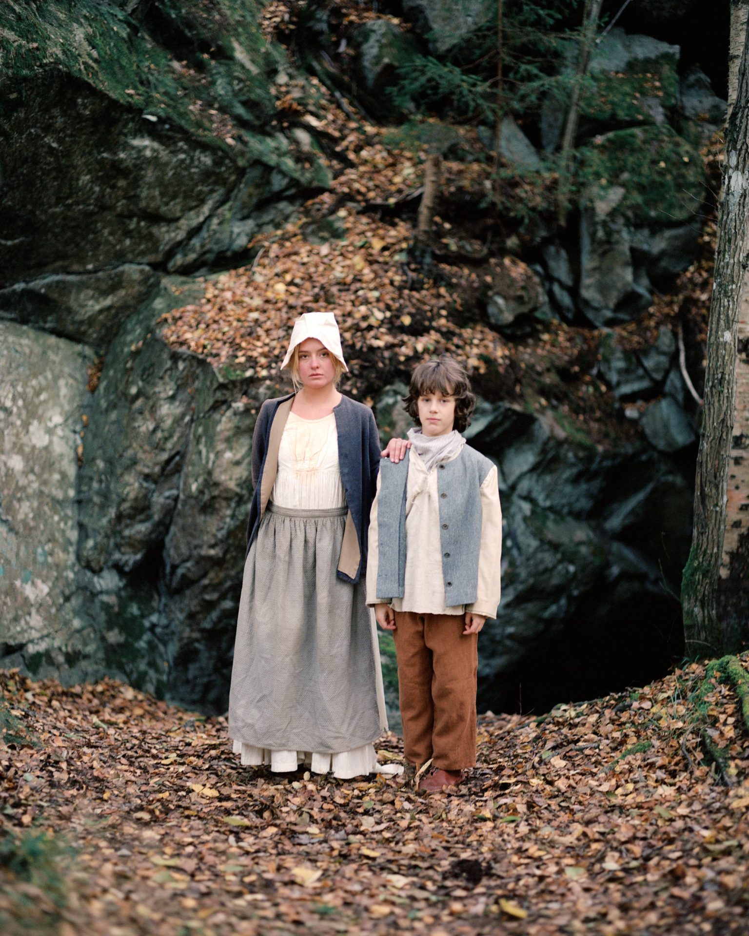 a woman and boy standing in the woods