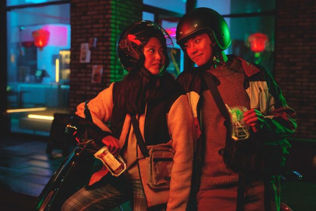 a man and woman wearing helmets and standing next to each other