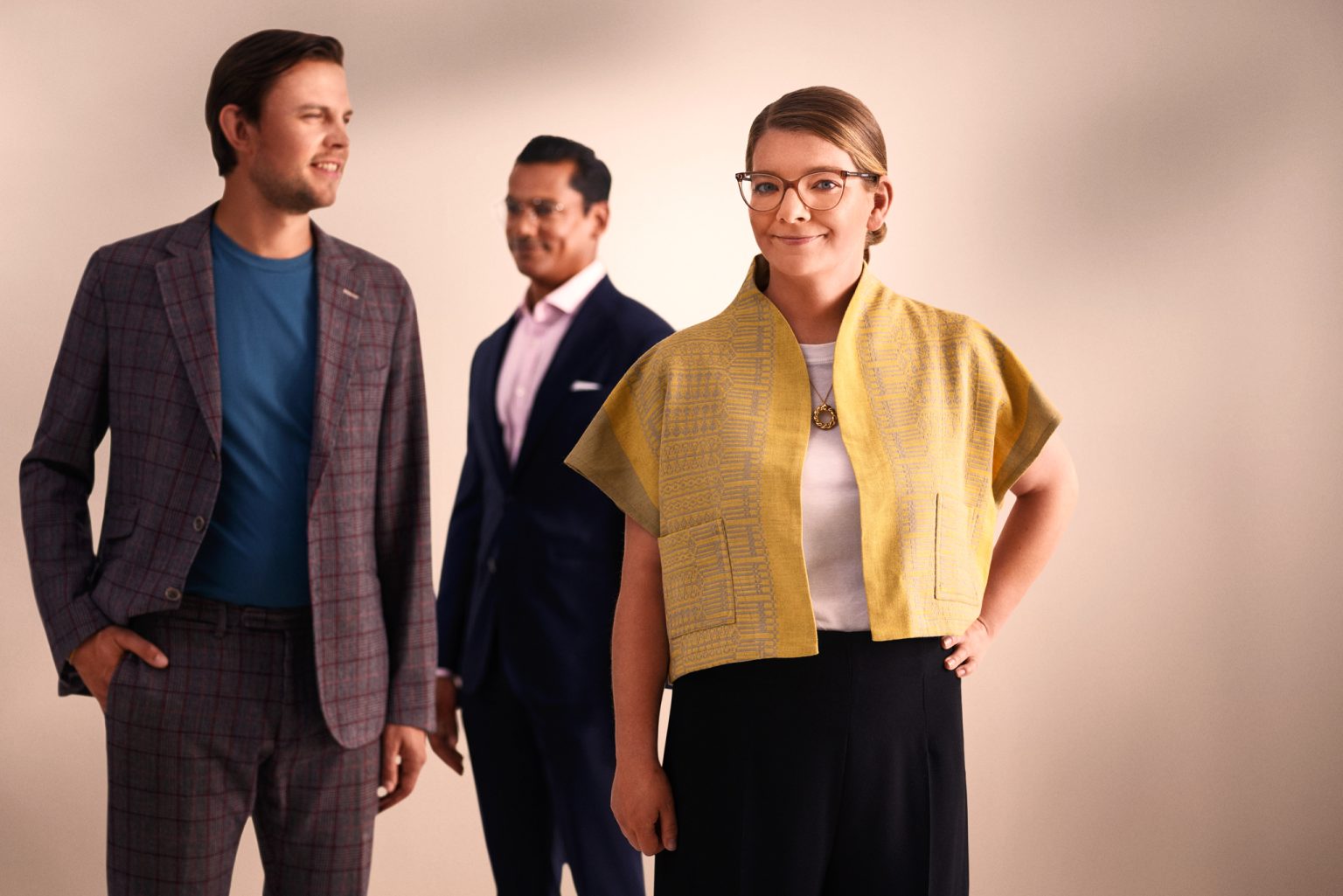 a group of people standing in front of a white wall