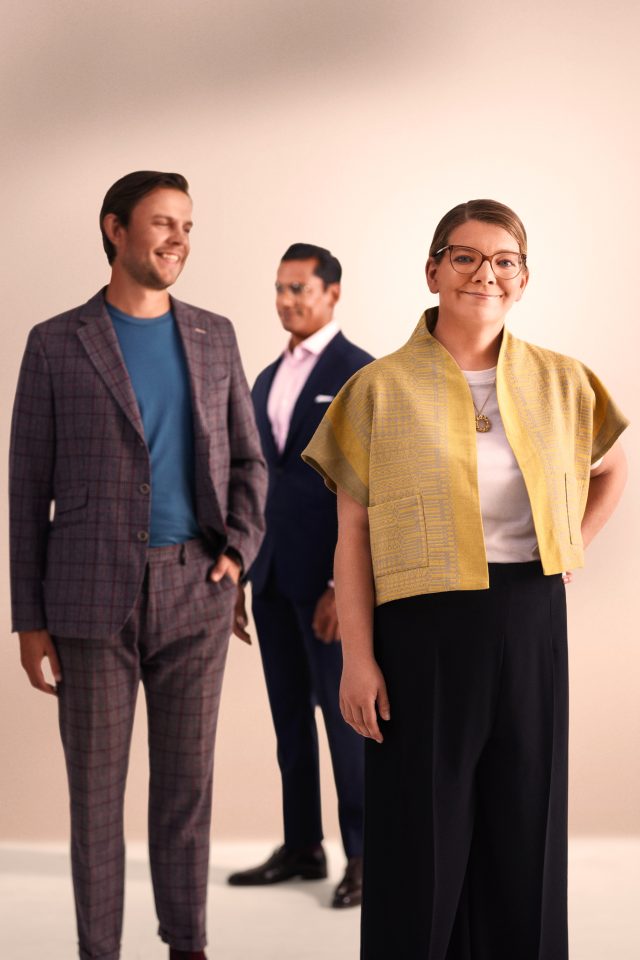 a woman smiling with other people in the background