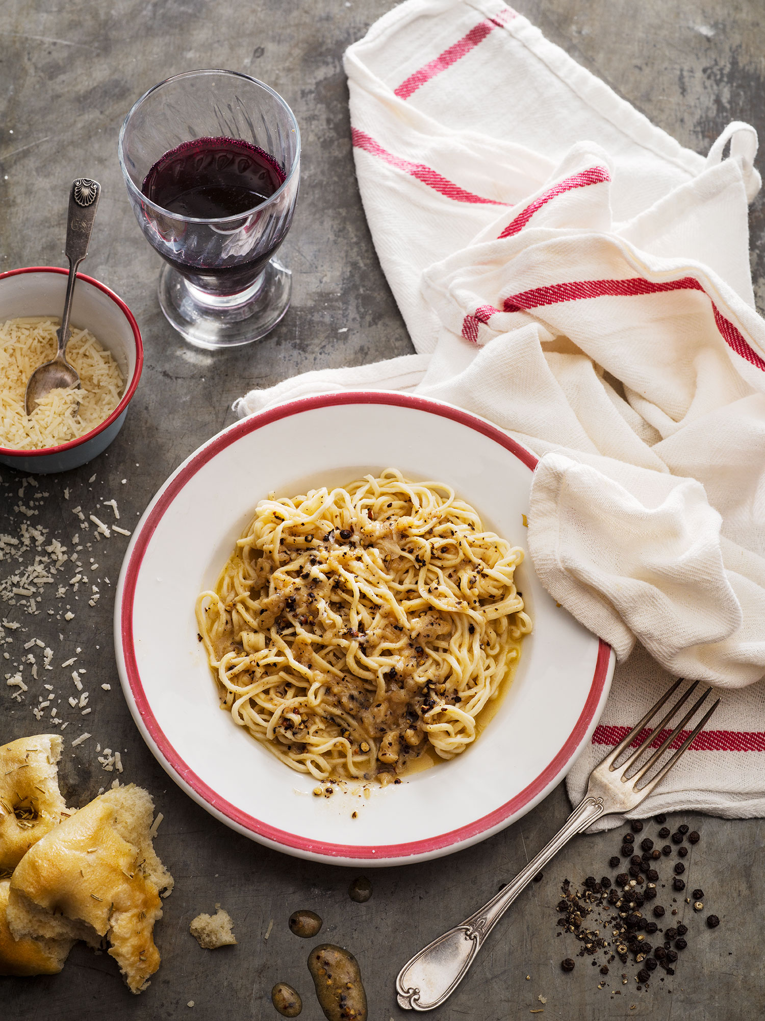a plate of noodles and a glass of wine
