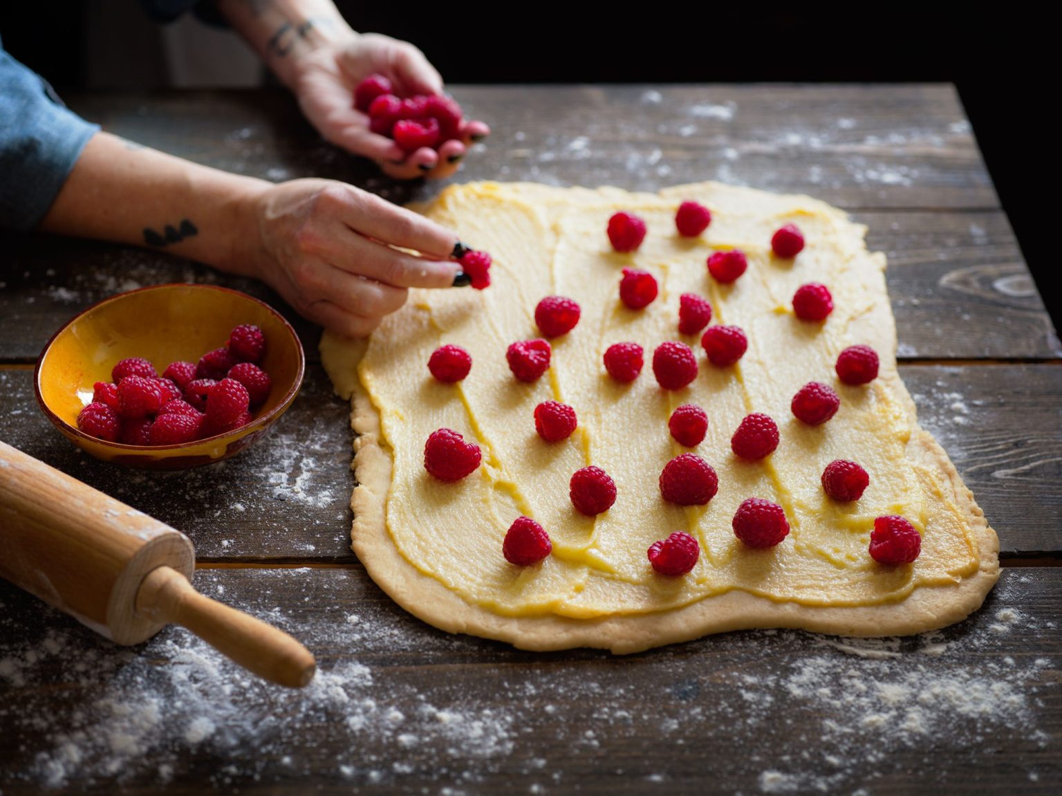 a person making a dessert with raspberries