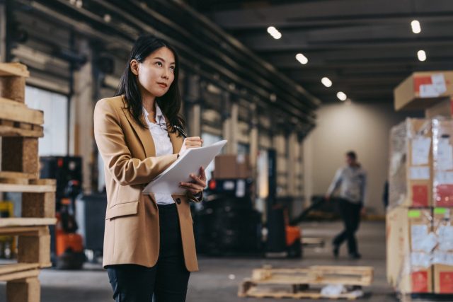 a woman holding a clipboard in a warehouse