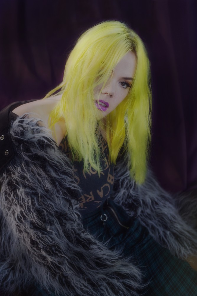 a woman with yellow hair and purple lipstick