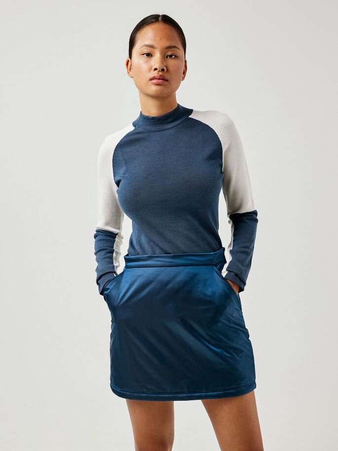 a woman with short hair wearing a blue and white shirt