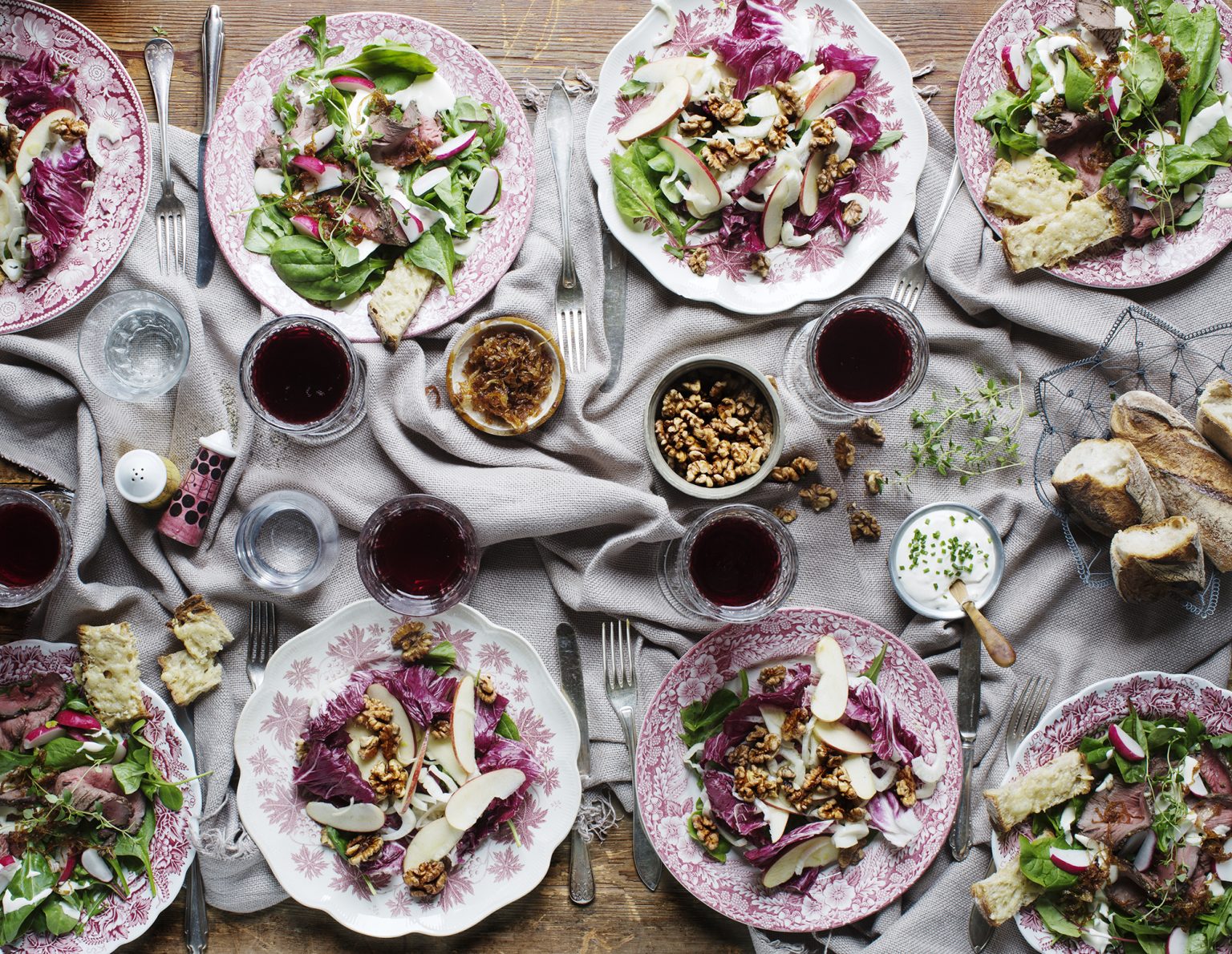 a table with plates of food and glasses of wine