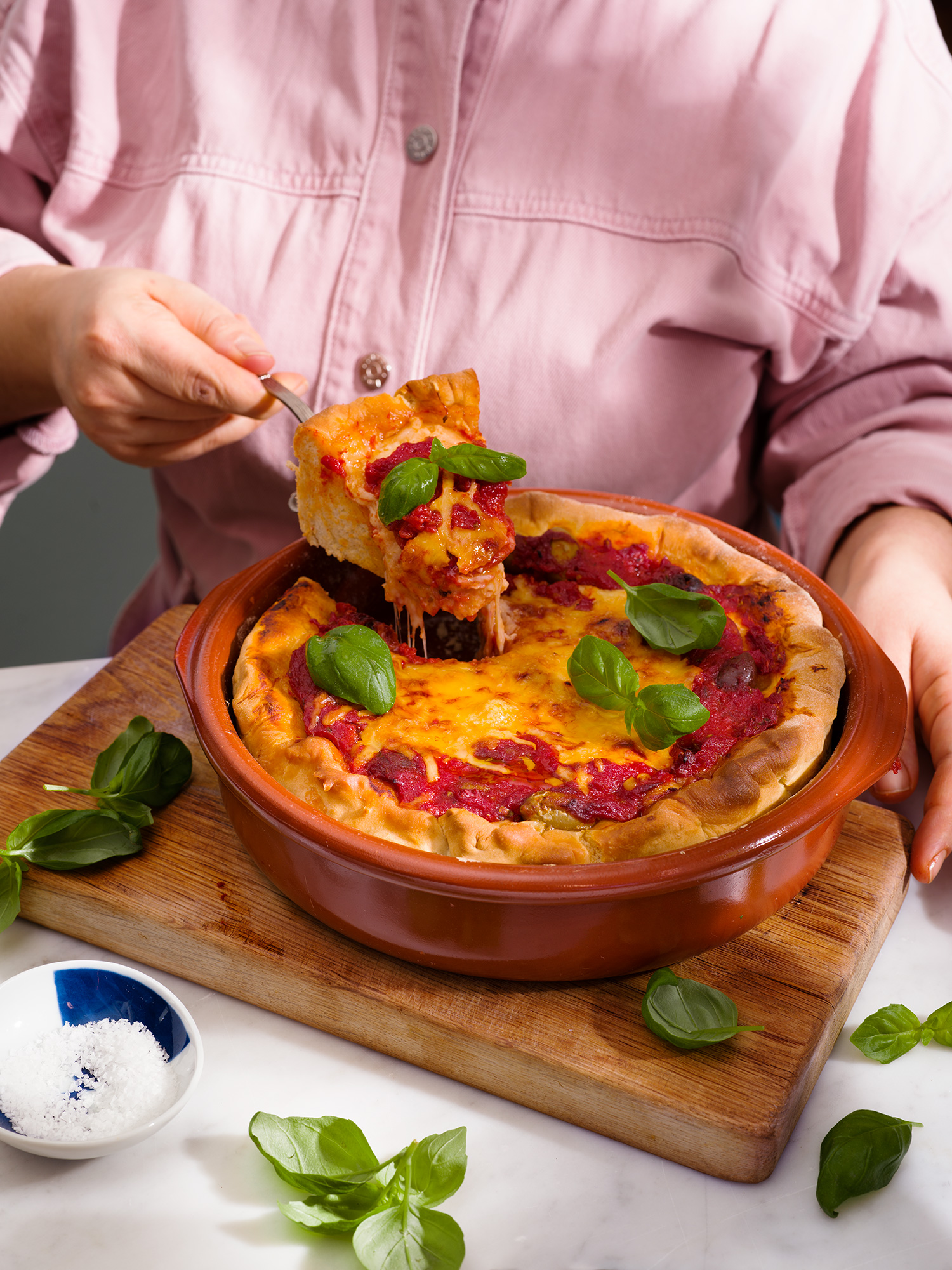 a person holding a piece of pizza