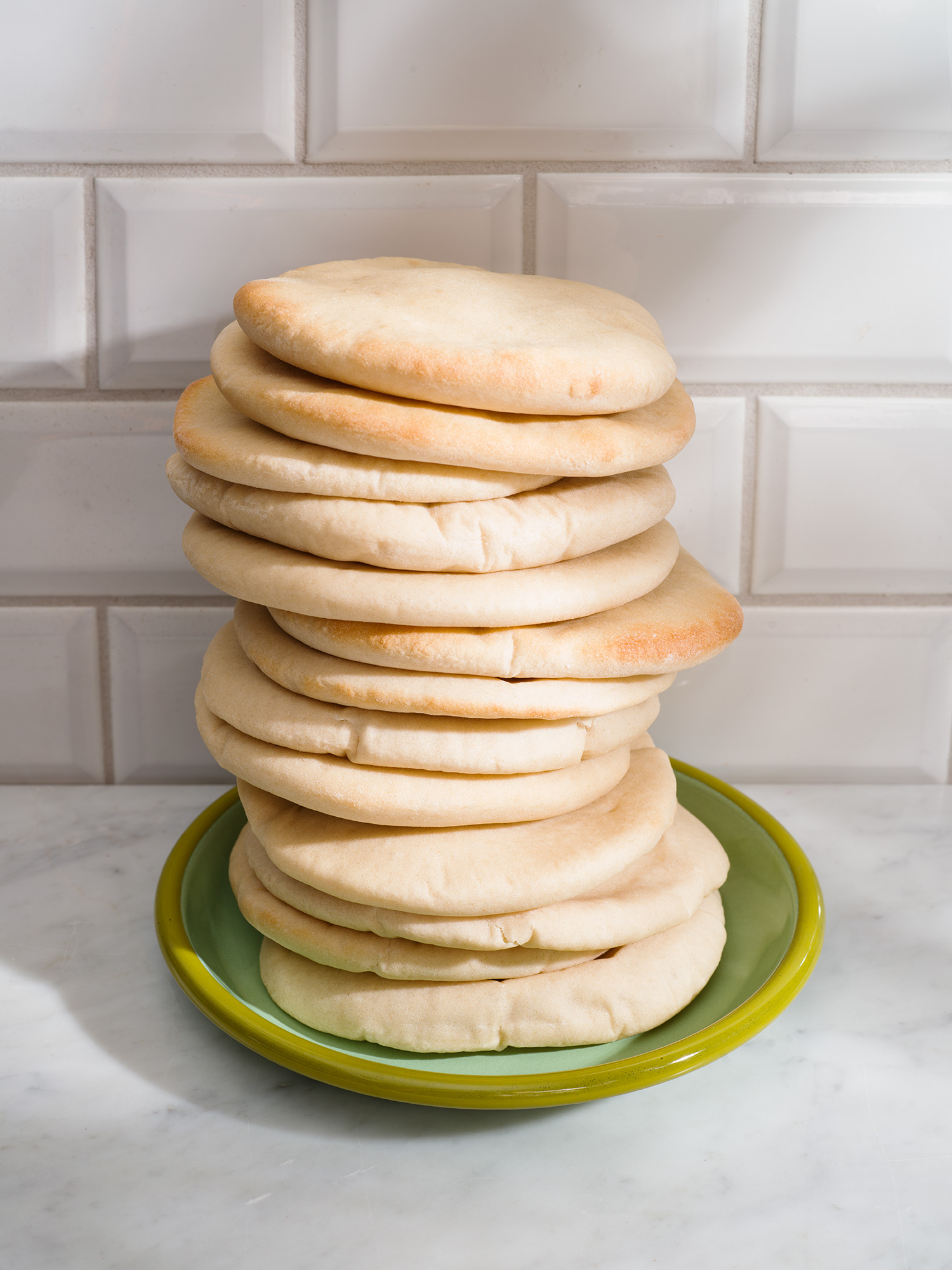a stack of flat bread on a green plate