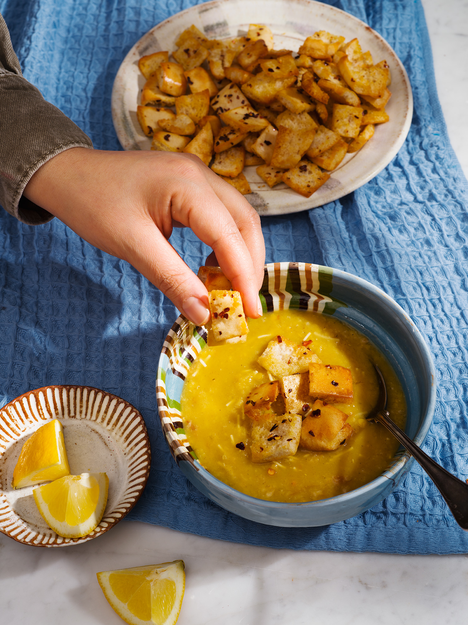 a person dipping food into a bowl