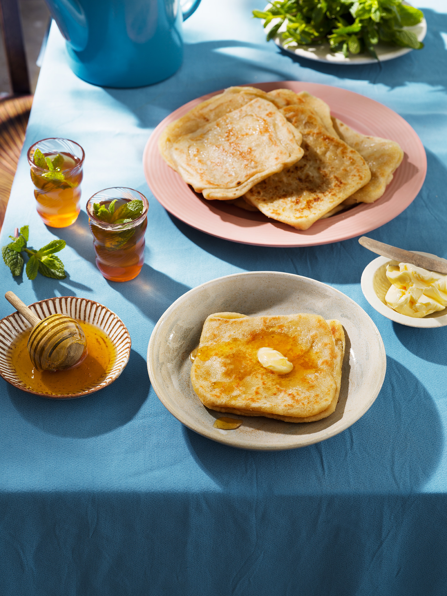 a table with plates of food and glasses of honey