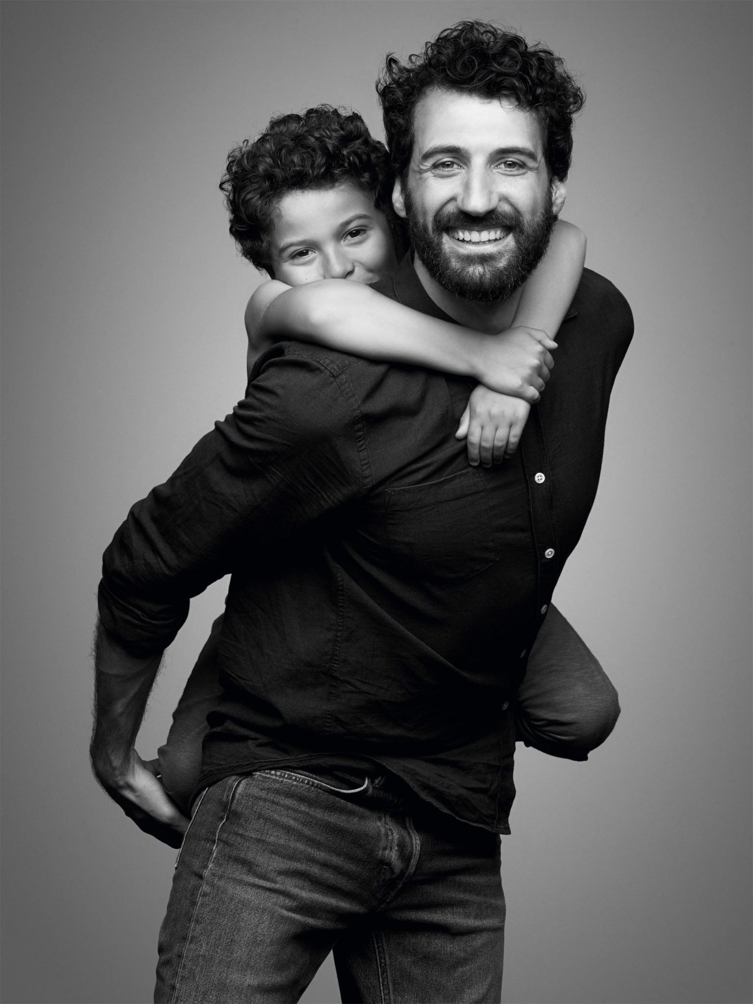 a man carrying a boy on his back