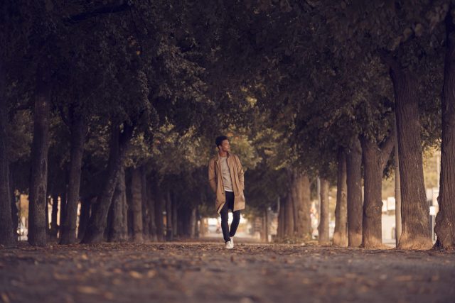 a man walking on a path with trees