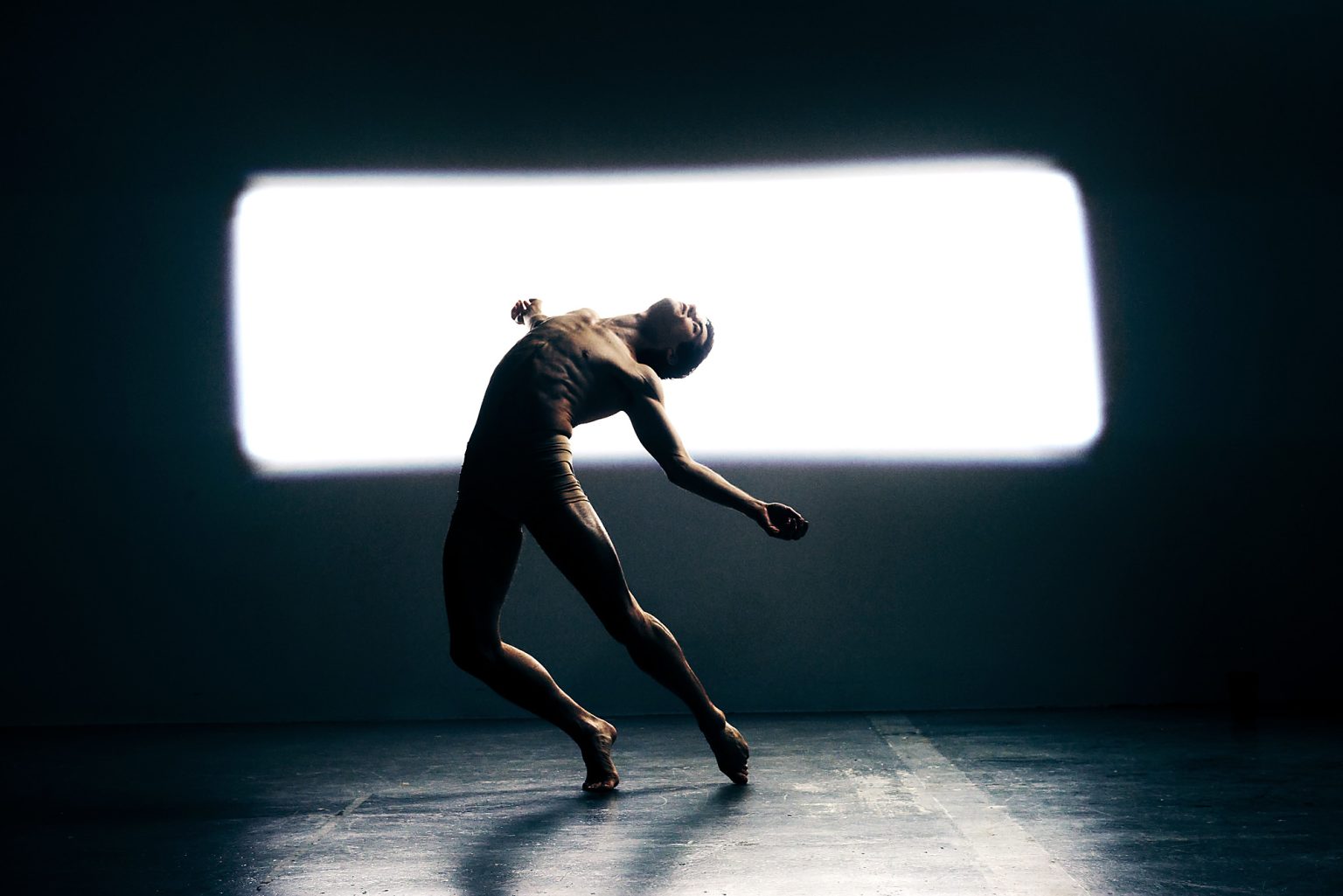 a man dancing in a dark room