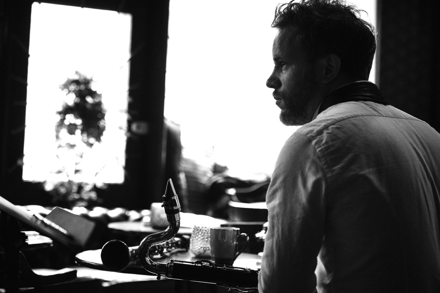 a man sitting at a table with a saxophone