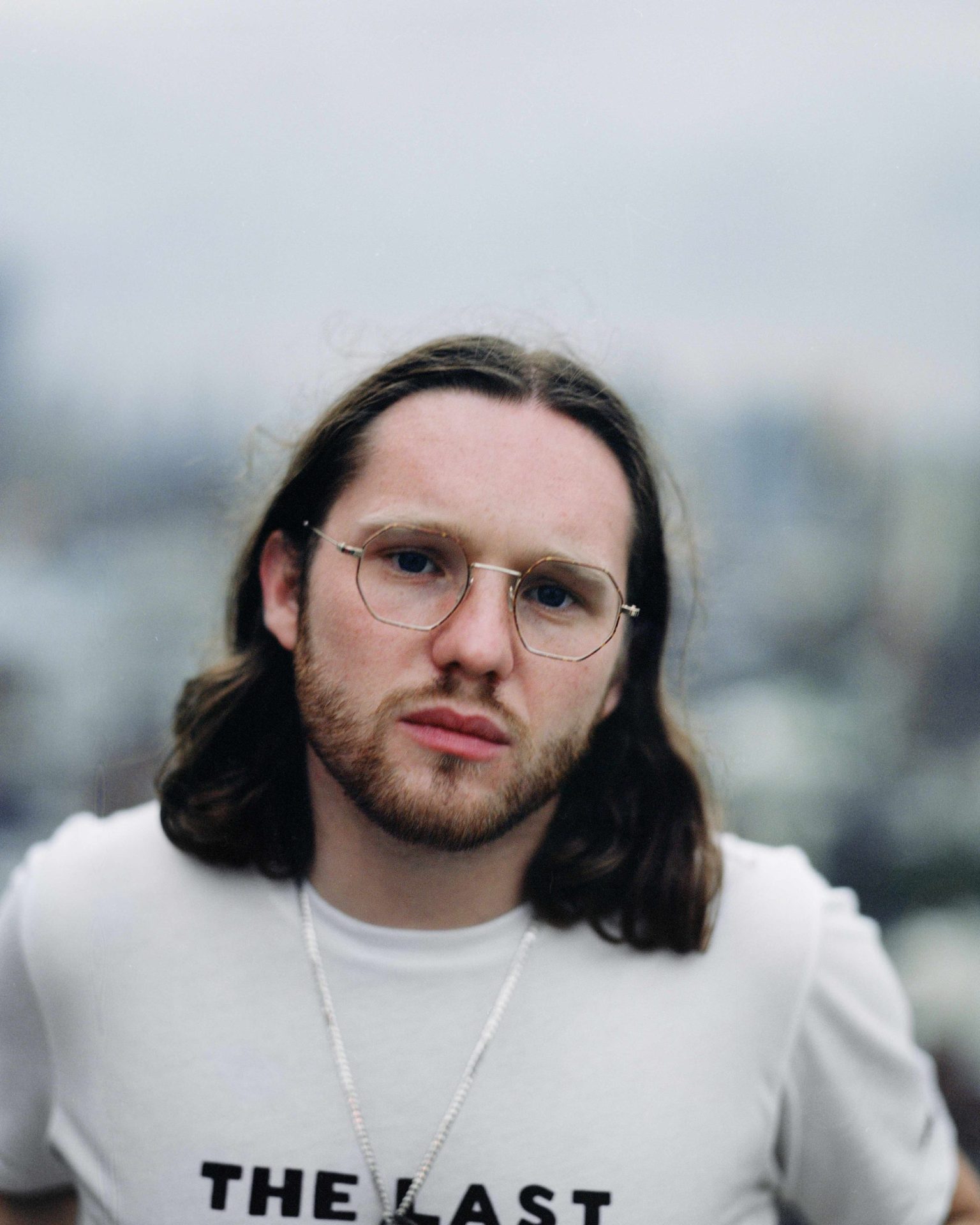 a man with long hair wearing glasses