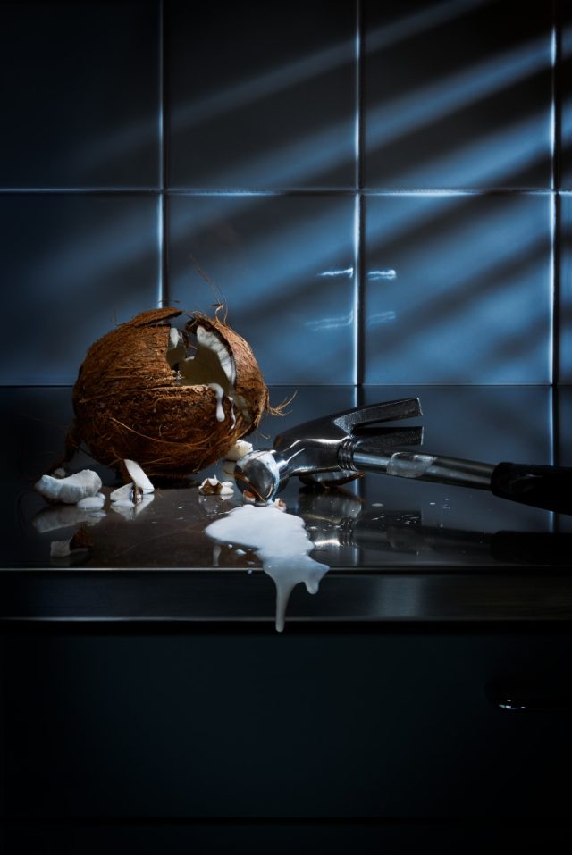 a coconut with milk and a hammer