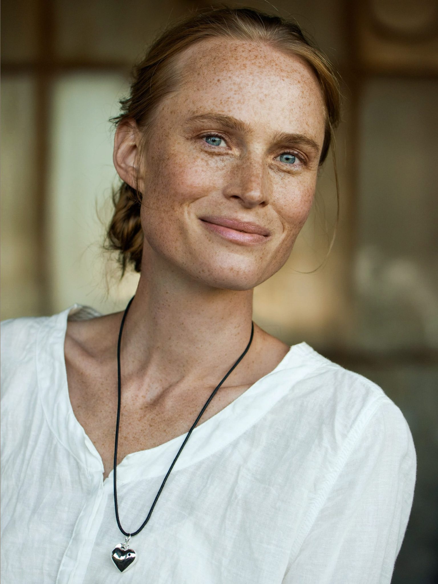 a woman with freckles wearing a white shirt