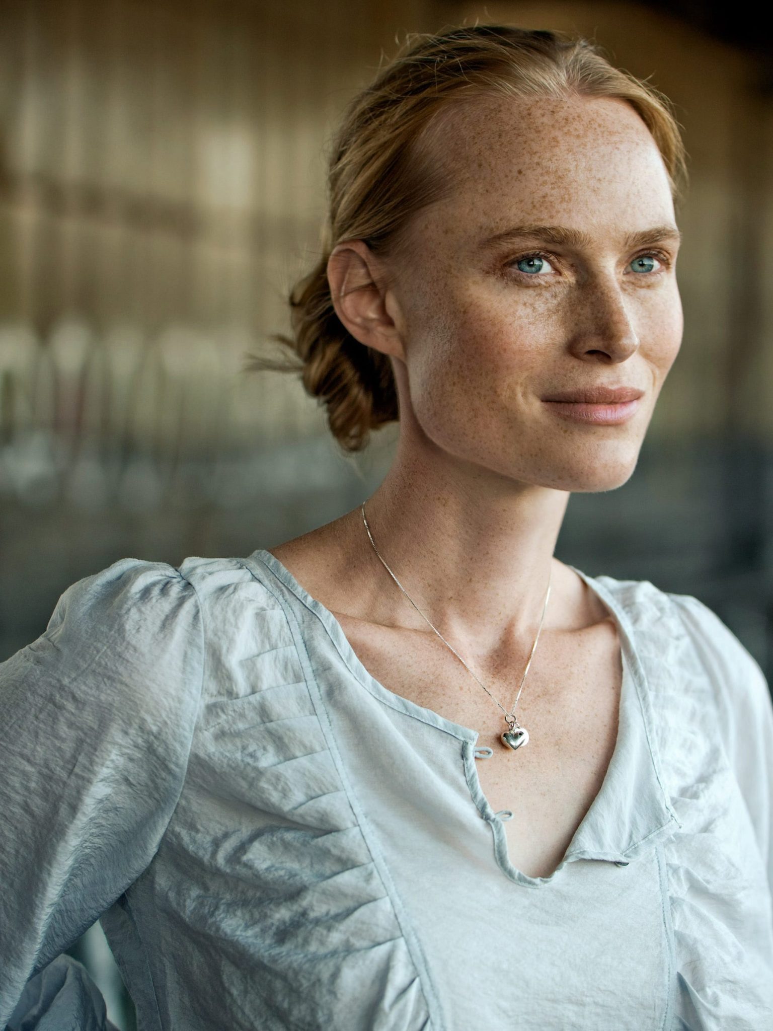 a woman with freckles wearing a white blouse