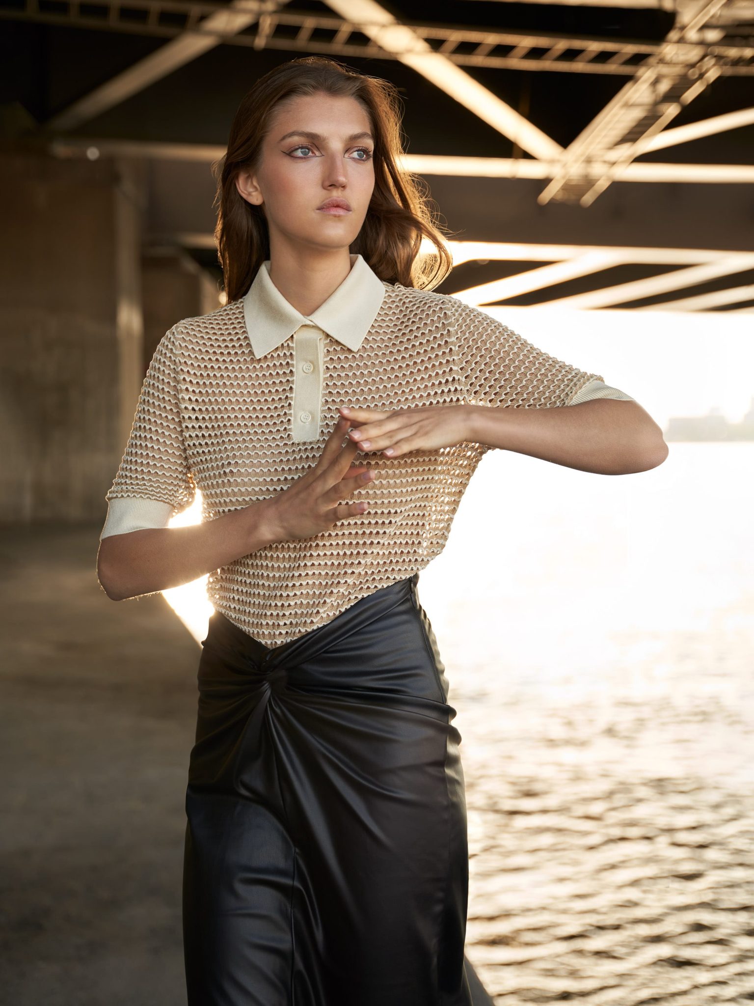 a woman standing under a bridge