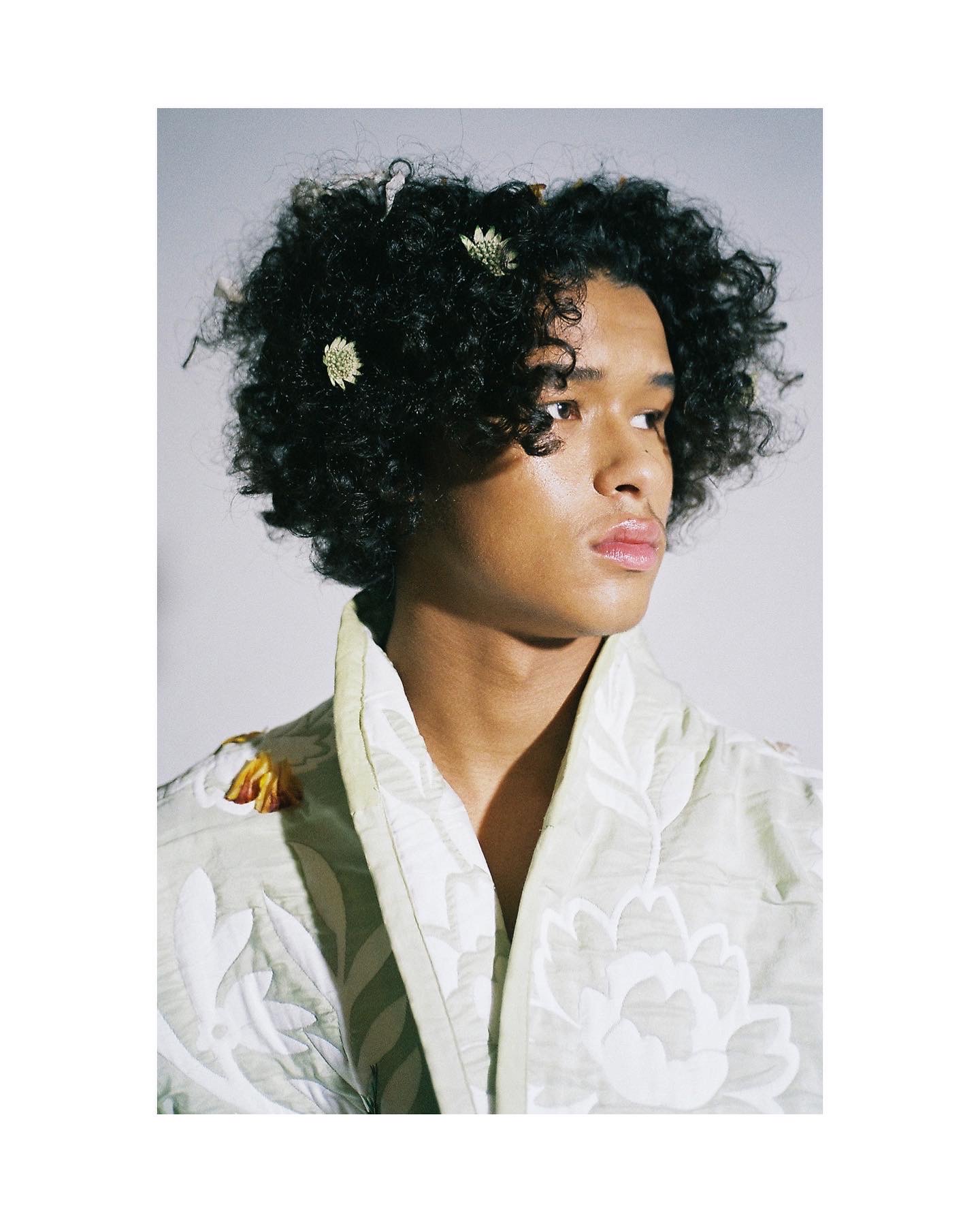 a man with flowers in hair