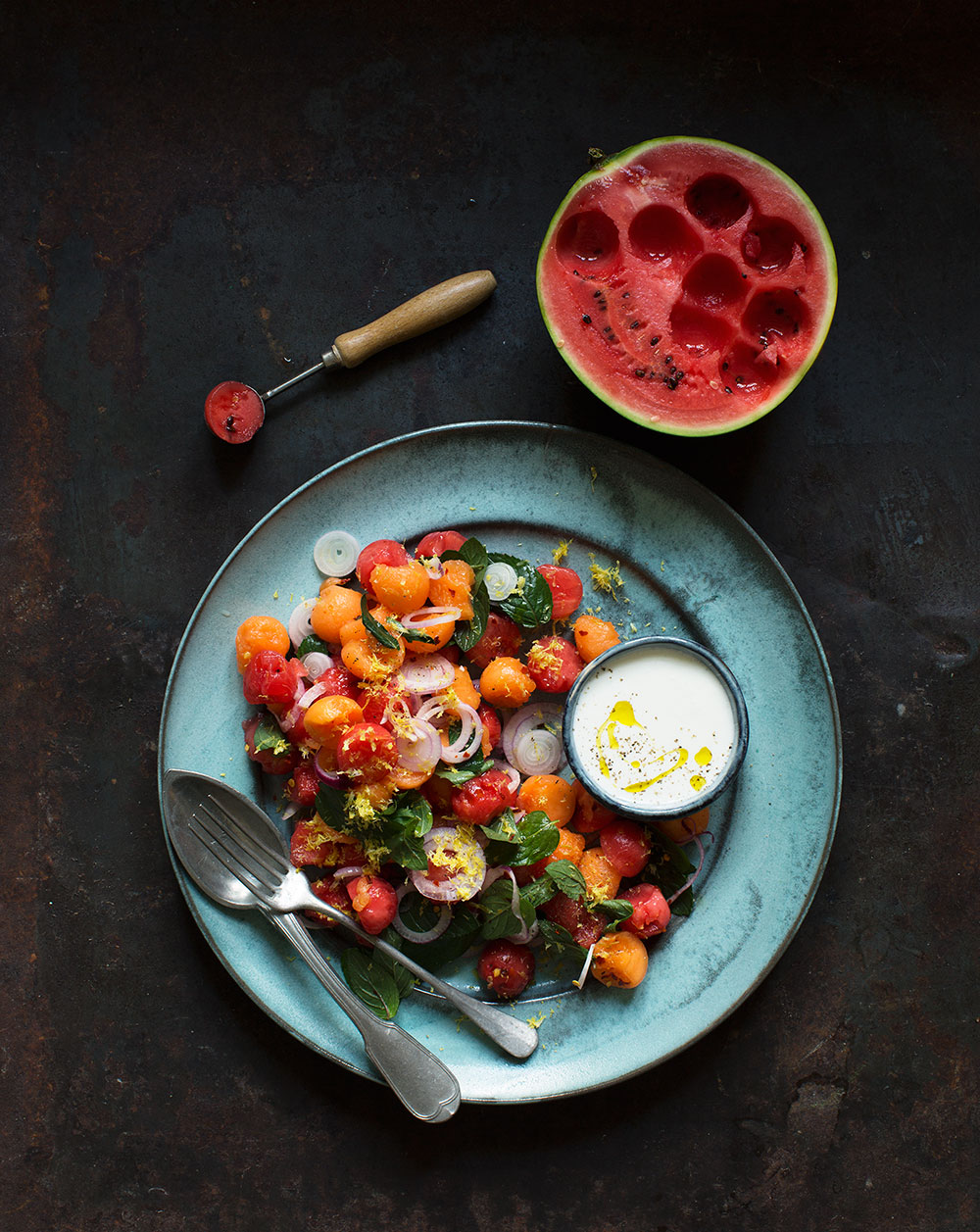 a plate of food next to a watermelon