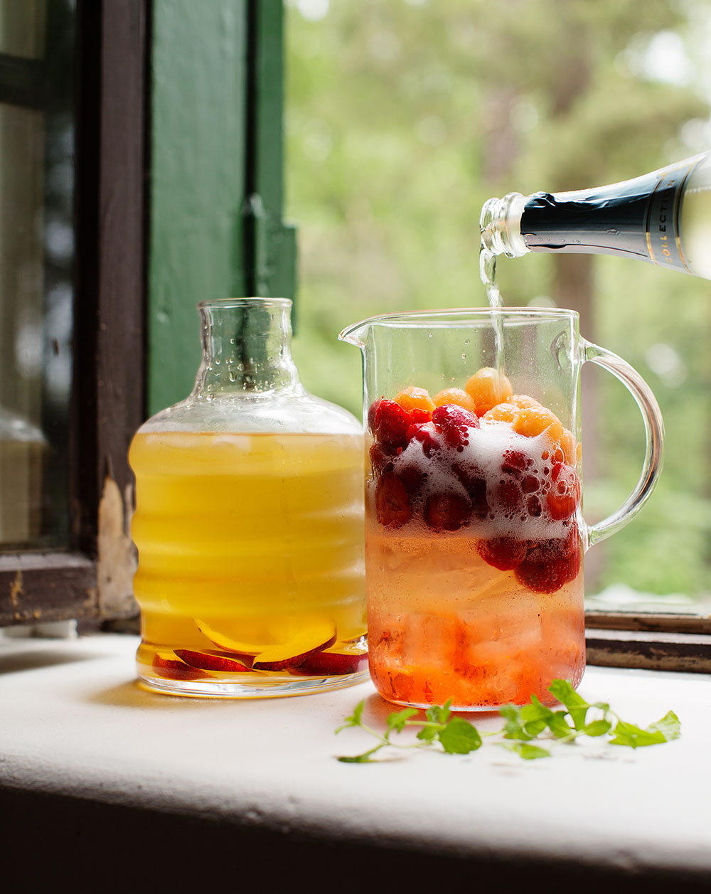 a pitcher of fruit juice and a bottle of champagne