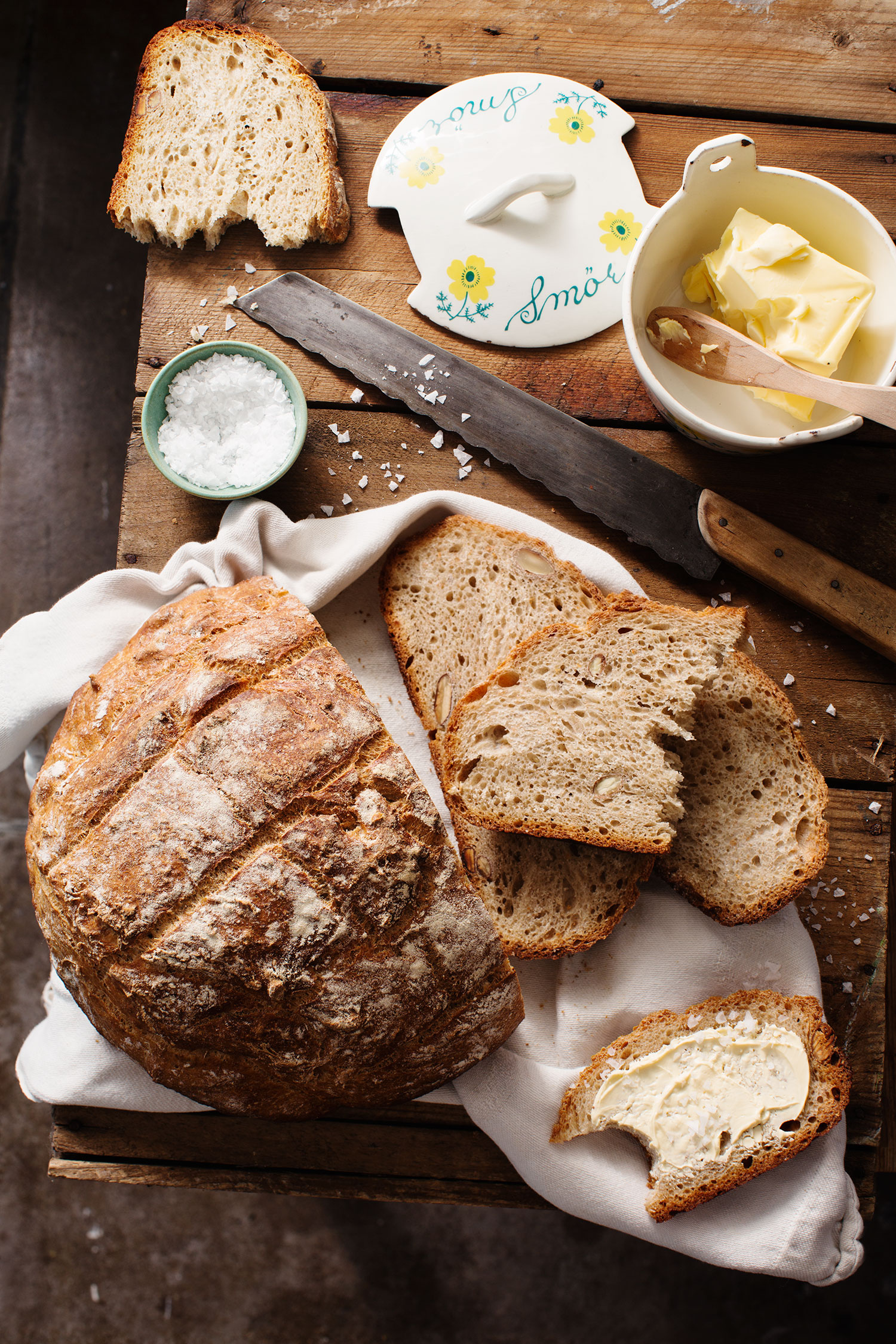 a loaf of bread with butter on a wooden surface