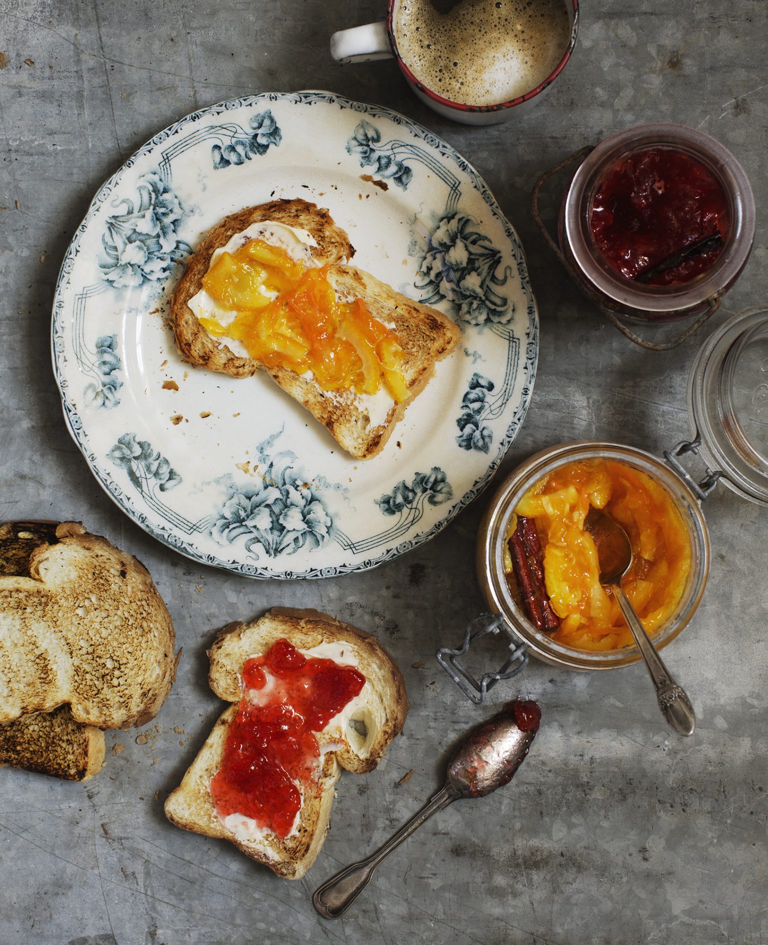 a plate of toast with jam and spoons