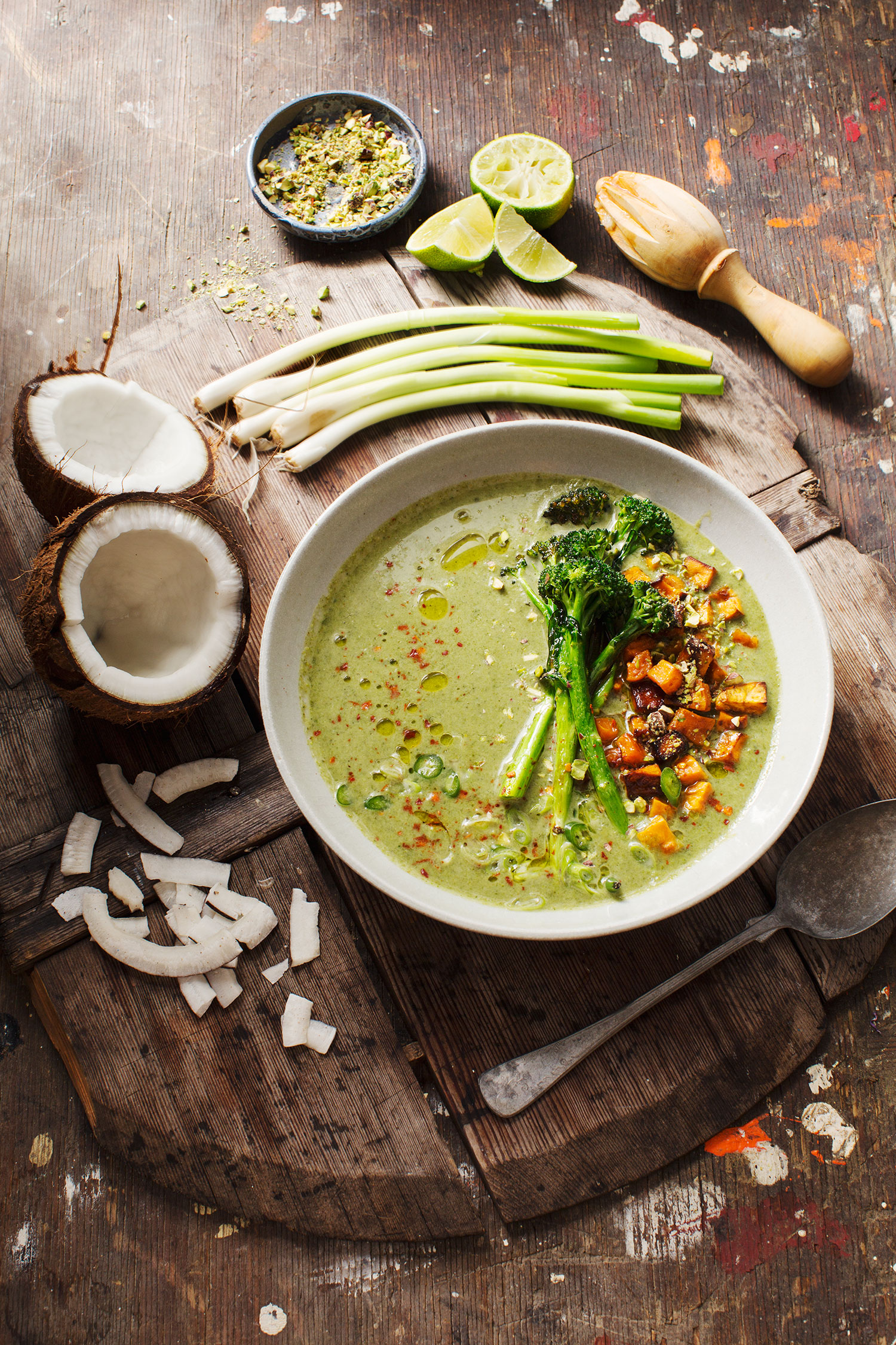 a bowl of soup with broccoli and coconuts