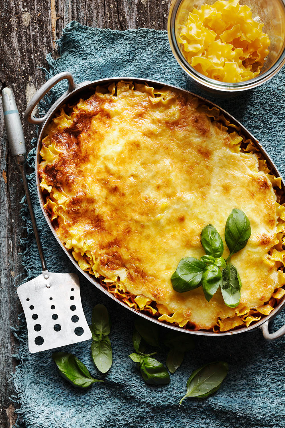 a casserole with cheese and basil in a pan