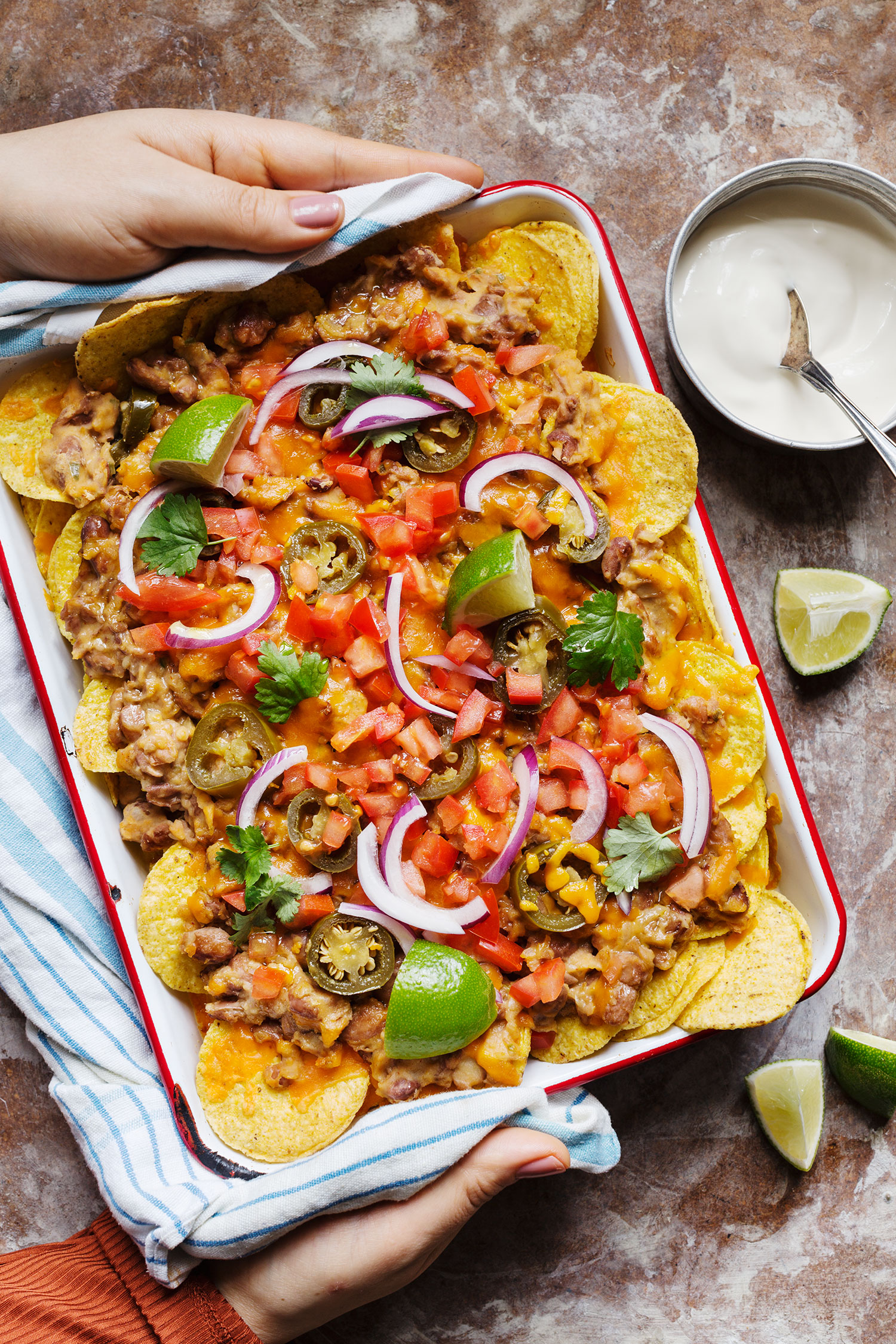 a dish full of nachos with vegetables and cheese