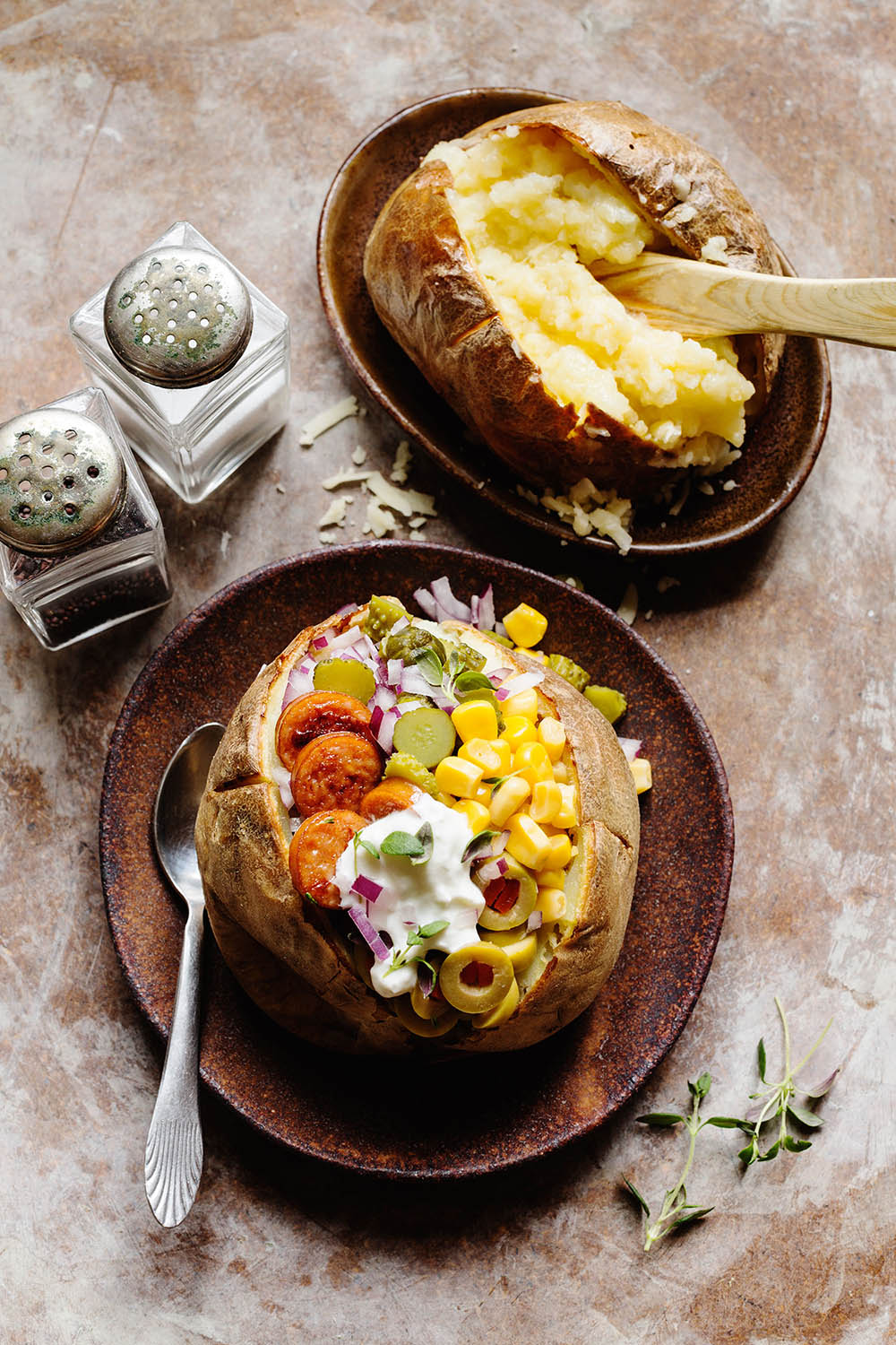 a baked potato with vegetables and a fork