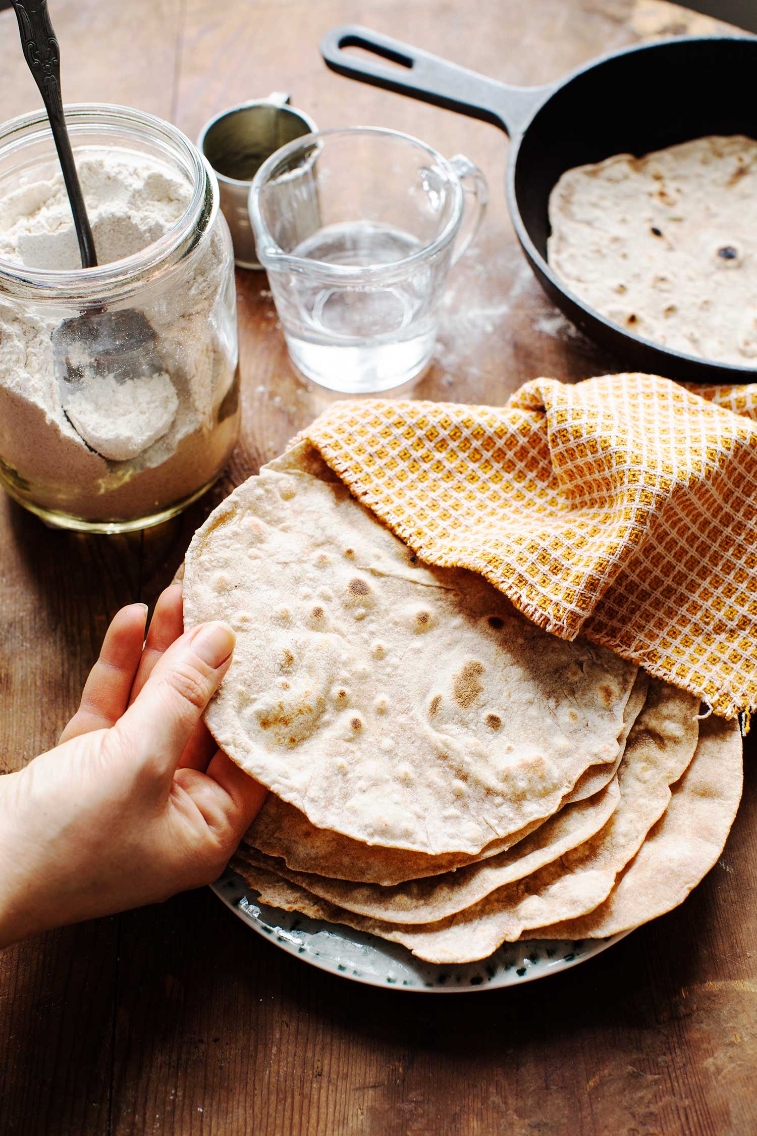 a hand holding a stack of flat bread