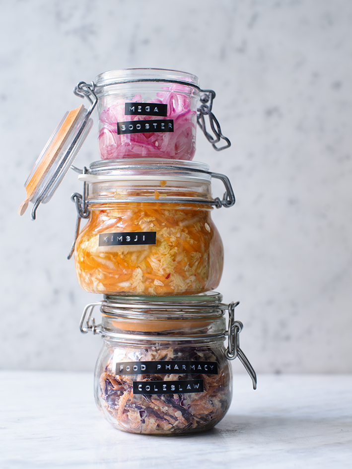 a stack of glass jars with different colored food items