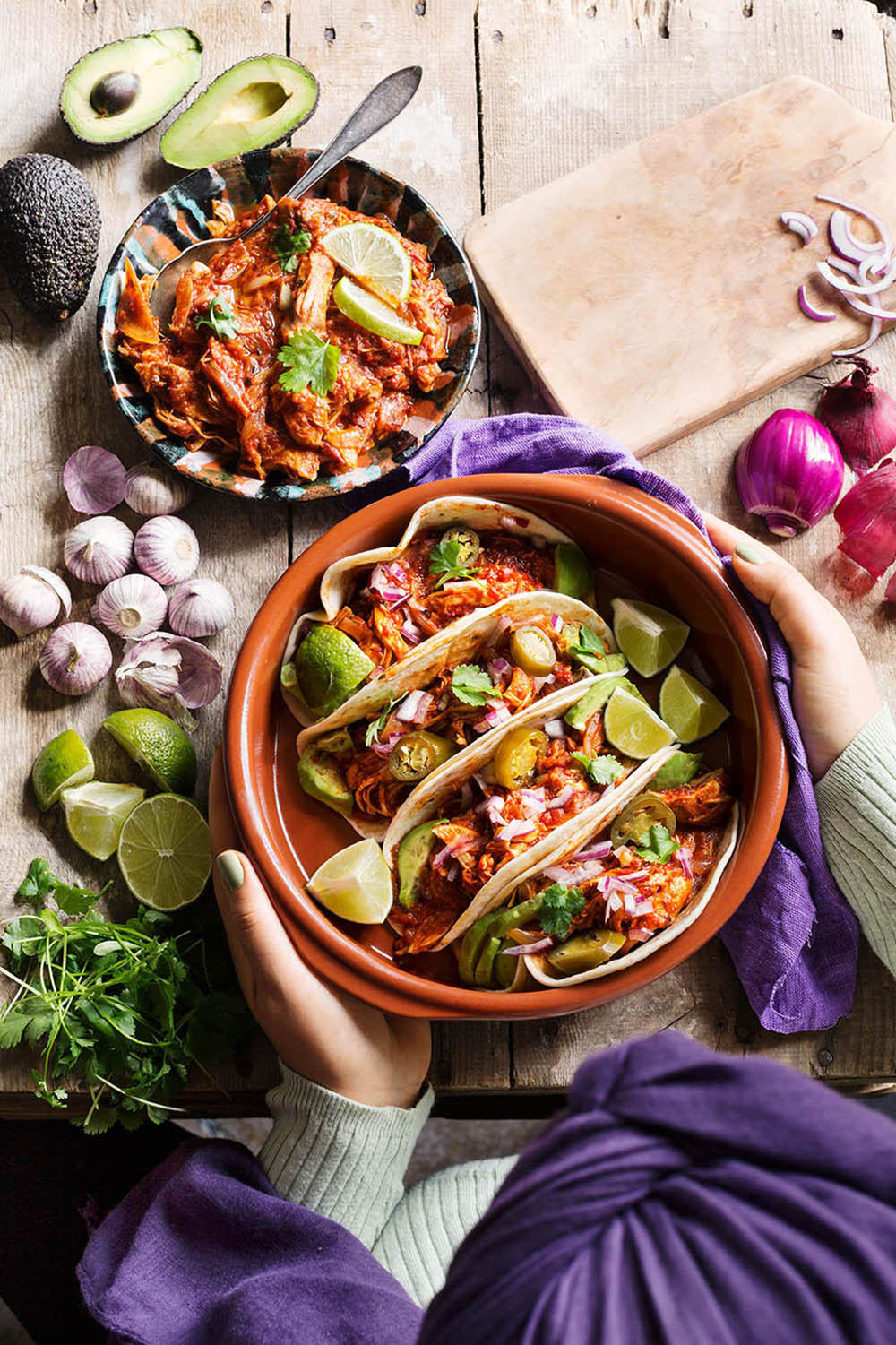 a person holding a bowl of tacos