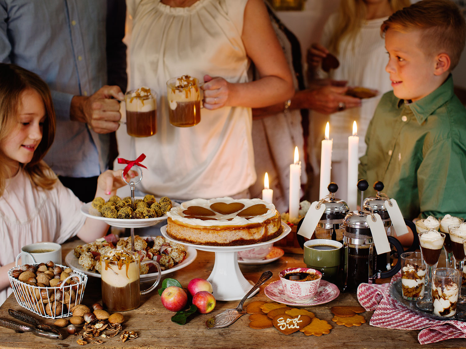 a group of people standing around a table with food and drinks