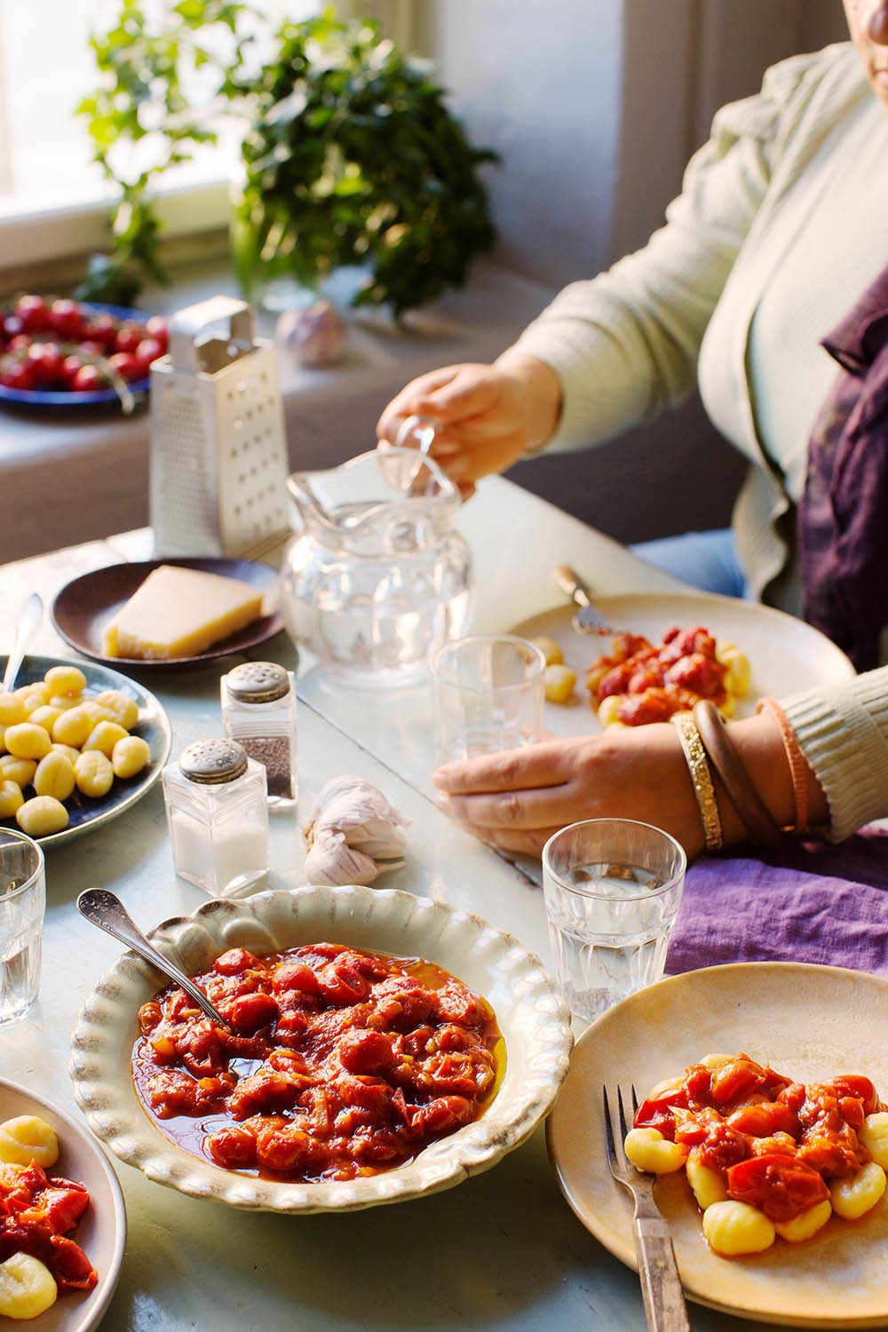 a person sitting at a table with plates of food