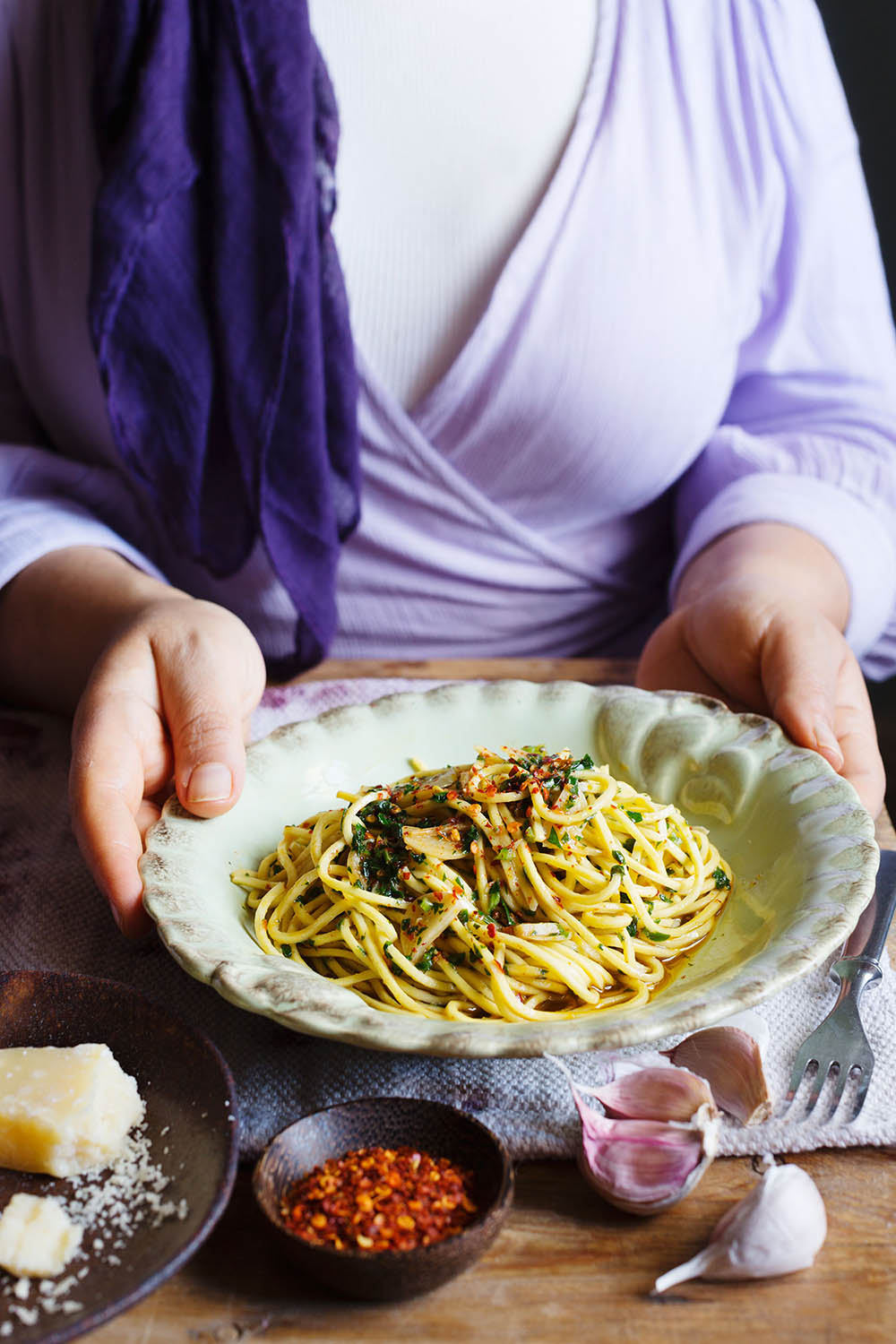 a person holding a plate of spaghetti