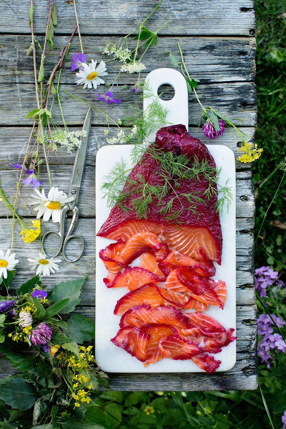 a cutting board with meat and flowers