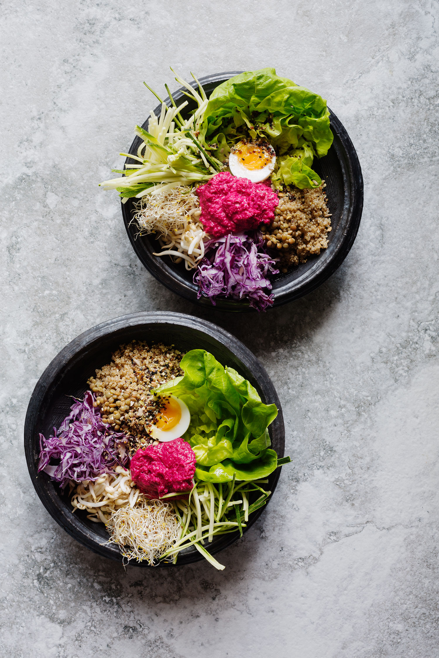 two bowls of food on a marble surface