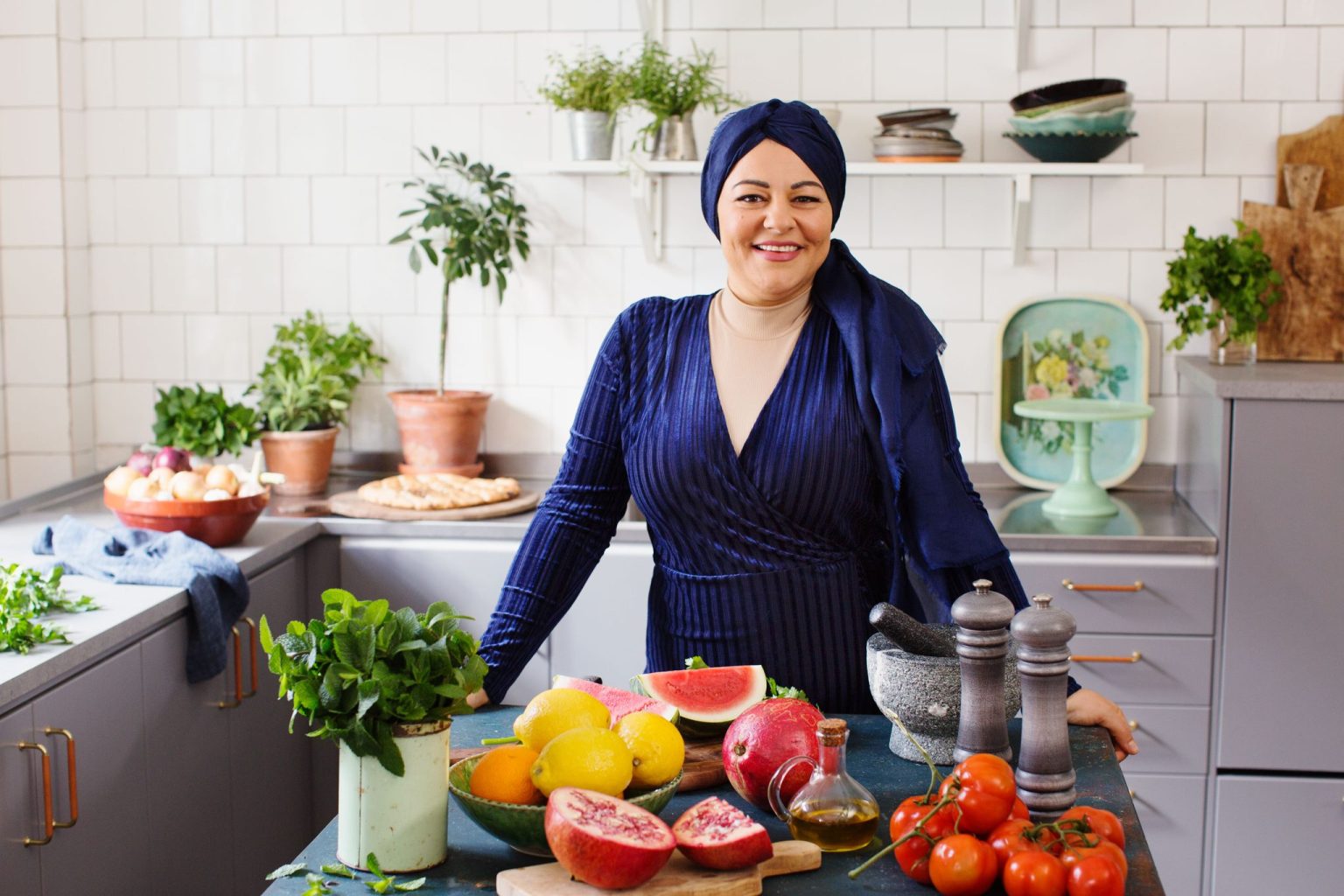a woman standing in a kitchen with fruits